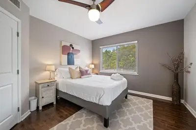 a bedroom with a large bed and a window at Classy 2BR Condo Near City Centre - OTR, UC, Zoo in Cincinnati