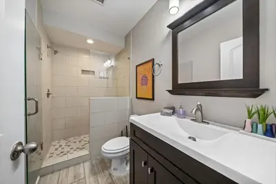 a bathroom with a sink and a toilet and a mirror at Classy 2BR Condo Near City Centre - OTR, UC, Zoo in Cincinnati