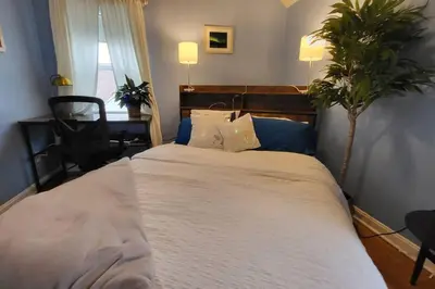 a bedroom with a large white bed with a plant at Cute 3 b 1 b Family home in Cle in Lyndhurst