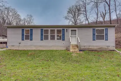 a small house with blue shutters on a yard at Pet-Friendly Home about 10 Mi to Hocking Hills! in South Bloomingville