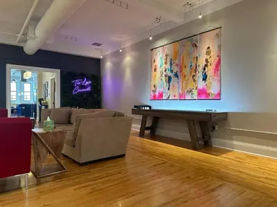 a living room with a couch and a large painting on the wall at The Historic Lyric Penthouse with Private Rooftop in Cincinnati