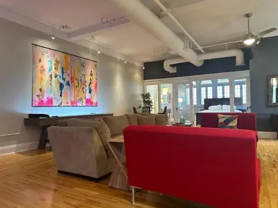 a living room with furniture and a large painting on the wall at The Historic Lyric Penthouse with Private Rooftop in Cincinnati