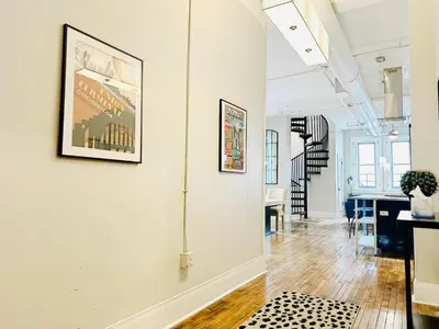 a hallway with a white wall with a painting on it at The Historic Lyric Penthouse with Private Rooftop in Cincinnati