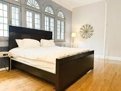 a bedroom with a large bed in a room with windows at The Historic Lyric Penthouse with Private Rooftop in Cincinnati
