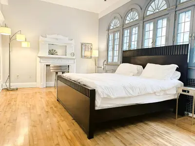 a bedroom with a large bed and a fireplace at The Historic Lyric Penthouse with Private Rooftop in Cincinnati