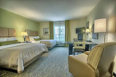 a hotel room with two beds and a desk at Candlewood Suites Columbus - Grove City by IHG in Grove City
