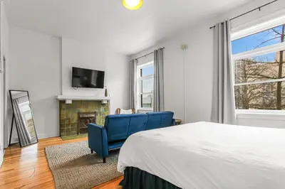 a bedroom with a bed and a chair and a fireplace at Library Square Suites in Toledo