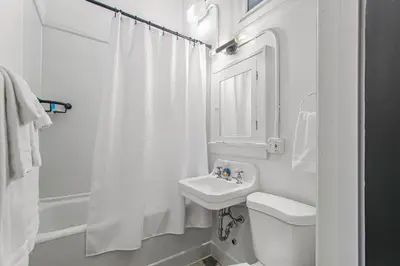 a white bathroom with a sink and a toilet at Library Square Suites in Toledo