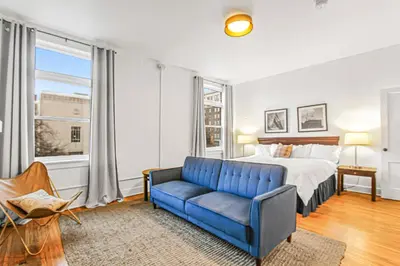 a bedroom with a bed and a blue couch at Library Square Suites in Toledo