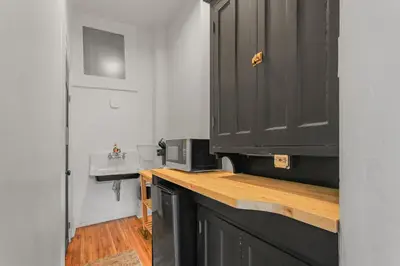 a kitchen with a black cabinet and a sink at Library Square Suites in Toledo