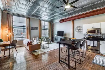 a large living room with a table and a kitchen at Good Vibes Loft - DT CLE Walk To All The Stadiums in Cleveland