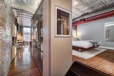 a bedroom with a bed and a mirror in a room at Good Vibes Loft - DT CLE Walk To All The Stadiums in Cleveland