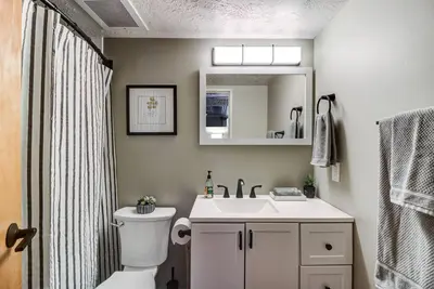 a bathroom with a toilet and a sink and a mirror at Good Vibes Loft - DT CLE Walk To All The Stadiums in Cleveland