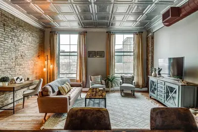 a living room with a couch and a tv at Good Vibes Loft - DT CLE Walk To All The Stadiums in Cleveland