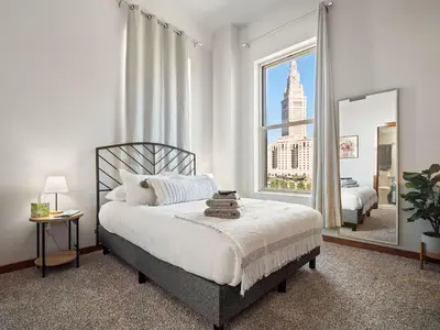 a bedroom with a bed and a large window at Skyloft Condo - Walk To Stadiums - City Views in Cleveland