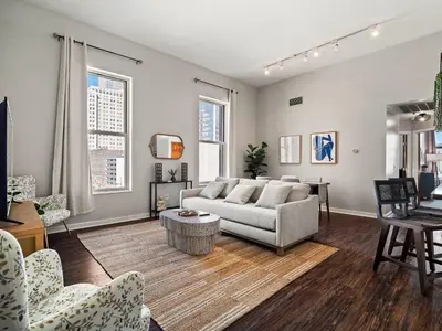 a living room with a couch and a table at Skyloft Condo - Walk To Stadiums - City Views in Cleveland
