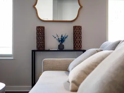 a living room with a mirror and a couch at Skyloft Condo - Walk To Stadiums - City Views in Cleveland