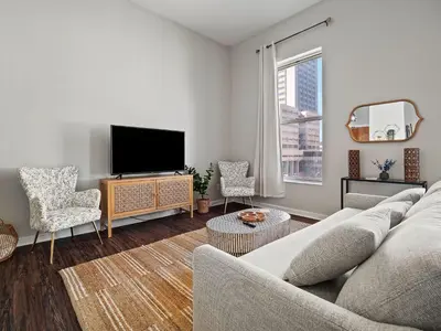 a living room with a couch and a flat screen tv at Skyloft Condo - Walk To Stadiums - City Views in Cleveland