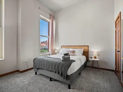 a bedroom with a bed and a large window at Skyloft Condo - Walk To Stadiums - City Views in Cleveland