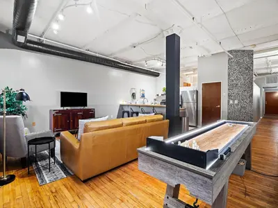 a living room with a couch and a table at Lakefront Loft - Downtown - Shuffle Board Table in Cleveland