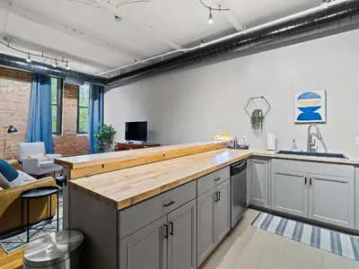 a kitchen with white cabinets and a counter top at Lakefront Loft - Downtown - Shuffle Board Table in Cleveland