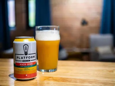 a glass of beer sitting next to a can of beer at Lakefront Loft - Downtown - Shuffle Board Table in Cleveland