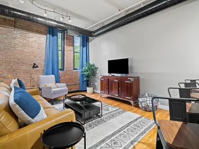 a living room with a couch and a tv at Lakefront Loft - Downtown - Shuffle Board Table in Cleveland
