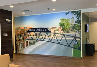 a large painting of a bridge on a wall at SureStay by Best Western Cambridge in Cambridge