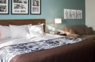 a bedroom with a large bed and a couch at SureStay by Best Western Cambridge in Cambridge