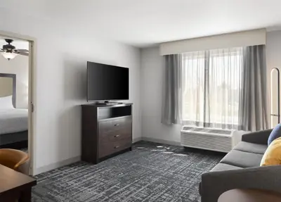 a hotel room with a flat screen tv and a couch at Homewood Suites by Hilton Akron/Fairlawn in Akron