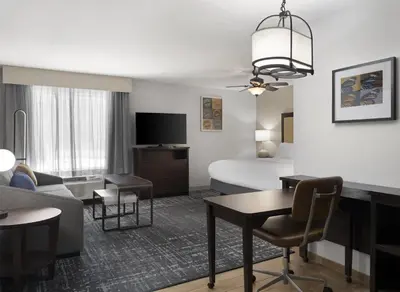 a hotel room with a bed and a living room at Homewood Suites by Hilton Akron/Fairlawn in Akron