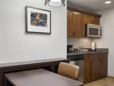 a kitchen with a table and a microwave at Homewood Suites by Hilton Akron/Fairlawn in Akron