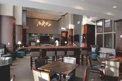 a restaurant with tables and chairs and a bar at Hampton Inn & Suites Columbus/University Area in Columbus