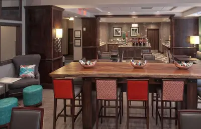 a large wooden bar in a room with chairs at Hampton Inn & Suites Columbus/University Area in Columbus