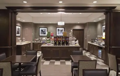 a restaurant with tables and chairs and a bar at Hampton Inn & Suites Columbus/University Area in Columbus