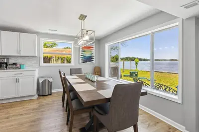 a kitchen and dining room with a table and a large window at Landmark Lakehouse - luxury living in PLX in Akron