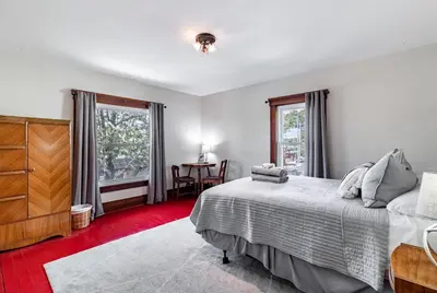 a bedroom with a bed and a dresser and two windows at Walk to Downtown Kent - 3 BR House w Patio & Yard in Kent