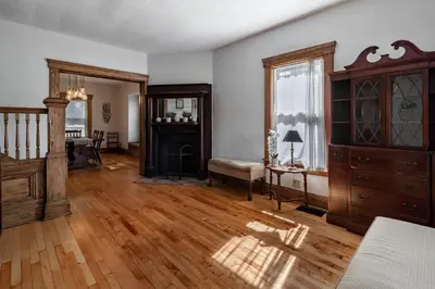 a large living room with wooden floors and a wooden dresser at Walk to Downtown Kent - 3 BR House w Patio & Yard in Kent