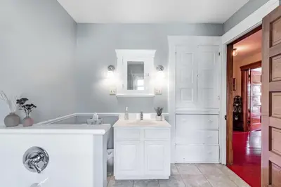 a white bathroom with a sink and a tub at Walk to Downtown Kent - 3 BR House w Patio & Yard in Kent