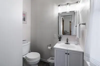 a white bathroom with a toilet and a sink at Walk to Downtown Kent - 3 BR House w Patio & Yard in Kent