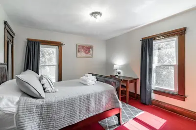 a bedroom with a bed and a desk and two windows at Walk to Downtown Kent - 3 BR House w Patio & Yard in Kent