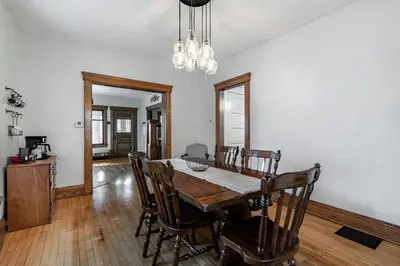 a dining room with a wooden table and chairs at Walk to Downtown Kent - 3 BR House w Patio & Yard in Kent