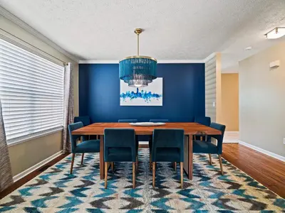 a dining room with a blue wall and a wooden table and chairs at Steps to CLE Clinic - Great for Families - ADA in Cleveland