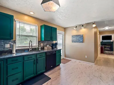 a kitchen with green cabinets and a window at Steps to CLE Clinic - Great for Families - ADA in Cleveland