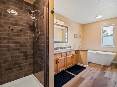 a bathroom with a shower and a tub and a sink at Steps to CLE Clinic - Great for Families - ADA in Cleveland