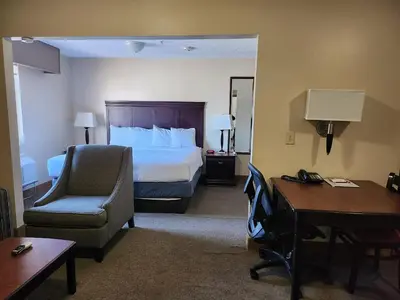 a hotel room with a bed and a desk and a chair at Ashley Quarters Hotel Airport-Cincinnati in Florence