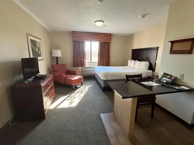 a hotel room with a bed and a desk at Ashley Quarters Hotel Airport-Cincinnati in Florence