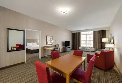 a hotel room with a table and chairs and a bed at Country Inn & Suites by Radisson, Findlay, OH in Findlay