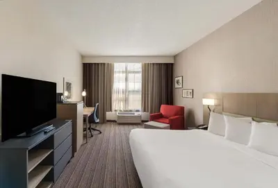 a hotel room with a bed and a flat screen tv at Country Inn & Suites by Radisson, Findlay, OH in Findlay