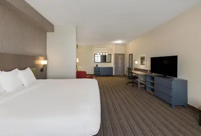 a hotel room with a bed and a flat screen tv at Country Inn & Suites by Radisson, Findlay, OH in Findlay